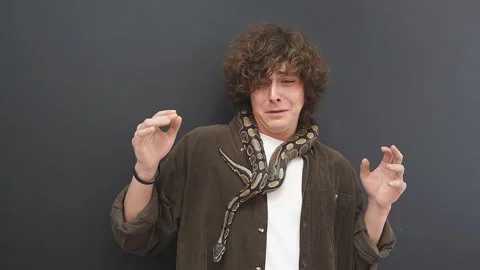 A person cannot move when a snake is wrapped around his neck and shoulders. A Stock Footage 157636559