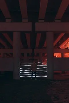 A person cannot pass through a neon gate painted with light at night under a  Stock Photos
