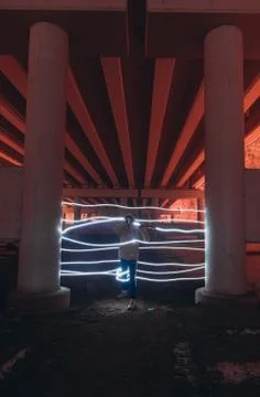 A person cannot pass through a neon gate painted with light at night under a  Stock Photos