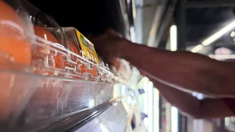 A person carefully arranges rows of eggs on a large, reflective surface 스톡 동영상 311885312