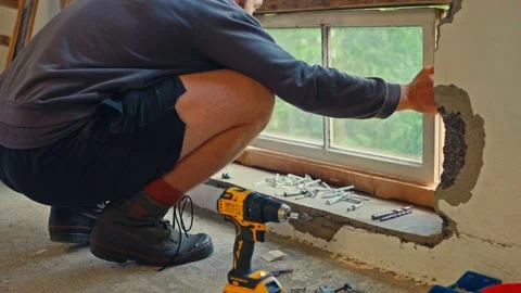 A Person is Carefully Installing a Window Frame While a Cordless Drill and Vidéo 336621511