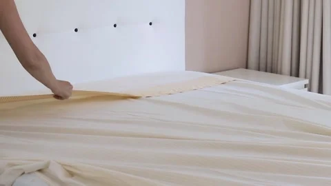 A person carefully performs a household task of making the bed Stock Footage 299335307