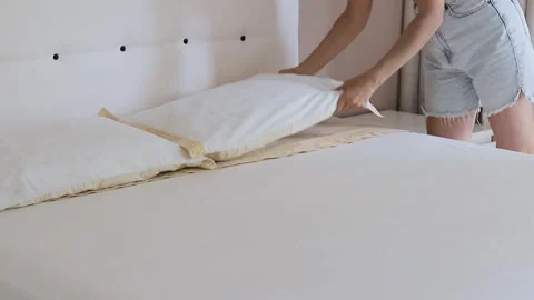 A person carefully performs a household task of making the bed Stock Footage 299335321