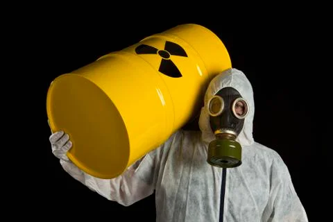 A Person Carrying A Radioactive Barrel And Wearing Protective Clothing Stock Photos