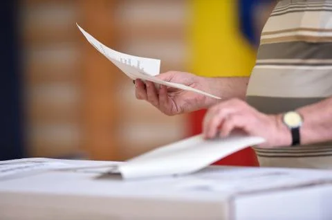 Person casting a vote into the ballot box during elections Stock Photos