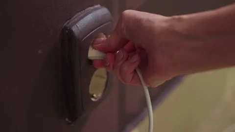 Person cautiously connecting wire to aging socket, meticulous approach to Stock Footage 323121585