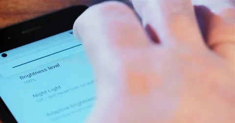 Person changes screen brightness level in settings of phone Stock-Footage 152445706