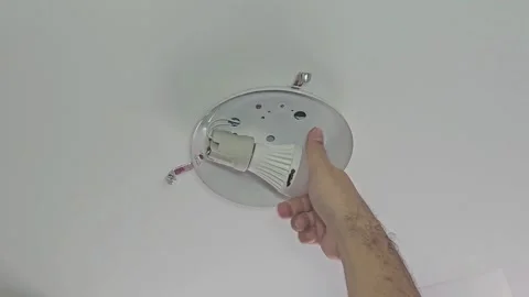 Person changing a ceiling light bulb in a home setting Stock-Footage 331300428