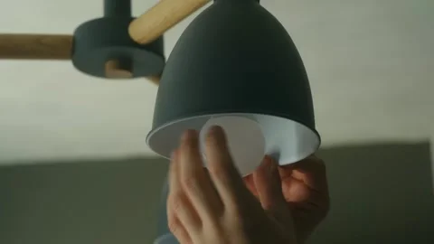Person changing light bulb in modern chandelier Video stock 321738434