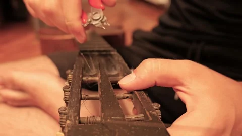 Person changing strings on an old acoustic guitar Stock Footage 341376330