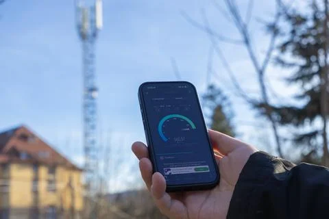A person checking 5G mobile internet speed on a smartphone with a cellular Stock Photos