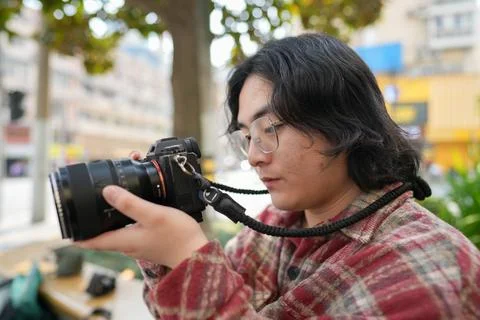 Person checking camera controls outdoors Photos
