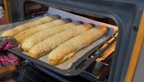Person checking cheese pies baking in oven tray Stock Footage 317981366
