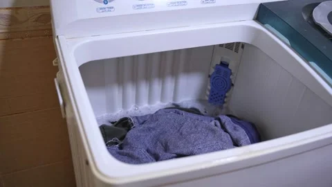 Person Checking Clothes in Spinning Top Loading Washing Machine Video stock 322561400