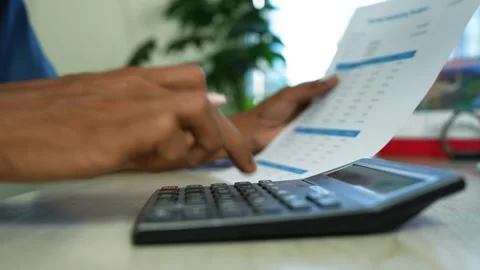 Person checking financial document with calculator, Close-up of a person ch.. Video stock 345120251