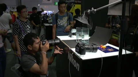 Person checking out camera at Photo Fair 2015 at BITEC in Bangkok, Thailand Stock Footage 57725748