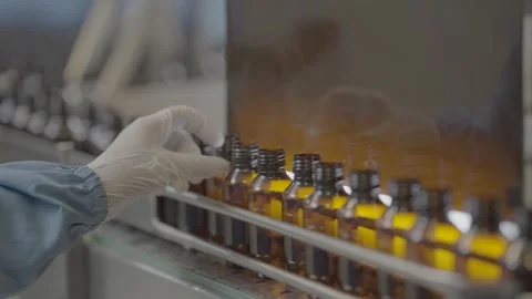 A person checking quality of syrup bottles slog footage. Stock Footage 301379705