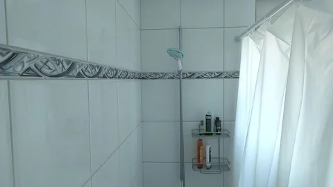 A person checking the temperature of the running water in the shower Stock Footage 127106912