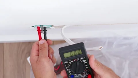 Person checking voltage in wall socket with digital multimeter Stock Footage 344874391