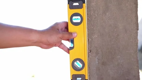 Person checking wall alignment with bubble level close up, construction work, Stock Footage 345289051