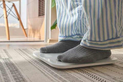 Person checking weight on scale for new year resolution Stock Photos
