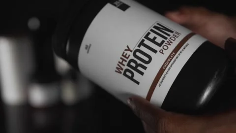 Person choosing a container of whey in a store 库存影片 330189771