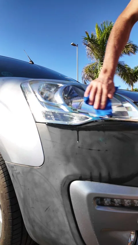 Person cleaning a car headlight with a microfiber cloth Vídeos de archivo 330554628