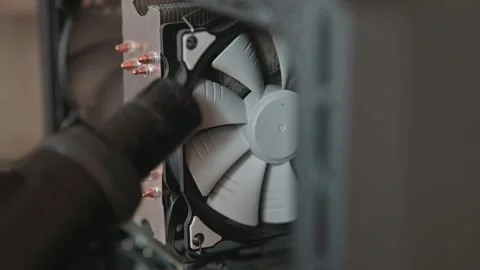 A person is cleaning a computer cooling fan using compressed air and vacuum Stockbeeldmateriaal 337112823