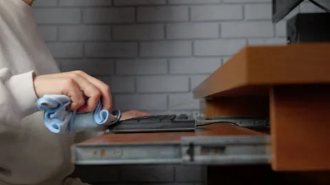 Person cleaning a computer keyboard with a microfiber cloth Stock Footage 334817118