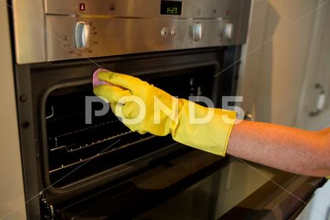 Person Cleaning The Oven At Home