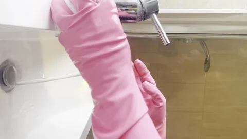 Person cleaning a surface while wearing pink gloves, ensuring hygiene Stock Footage 301105014