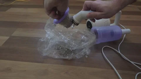 Person Cleaning a Vacuum Cleaner Filter with a Brush over a Plastic Trash Bag Stock Footage 345133490