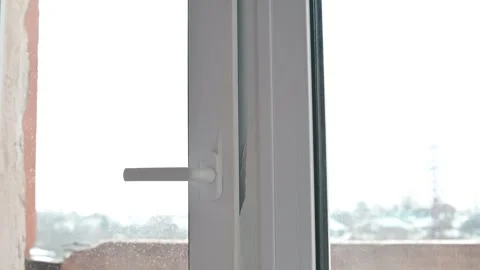 A person is cleaning a window using a cloth to remove dirt and improve Stockbeeldmateriaal 337111506