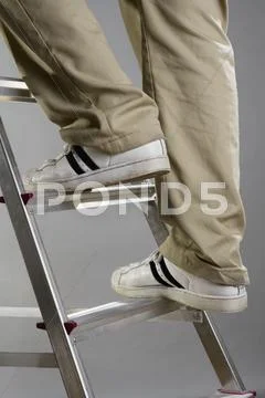 A person climbing a ladder Stock Photos