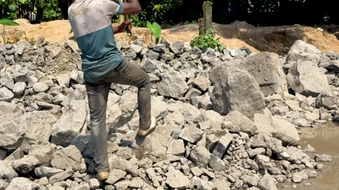 Person climbing over large gray rocks in a rugged outdoor setting with scat.. Stock Footage 339369285