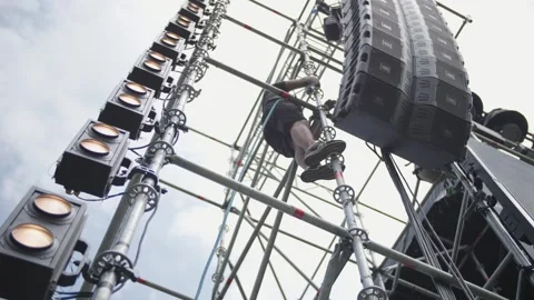 A person climbs onto a stage structure during stage installation. Stock Footage 258336606