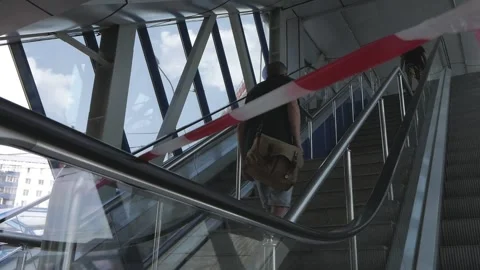 A person climbs up the steps next to a non-working escalator Stock Footage 158226384