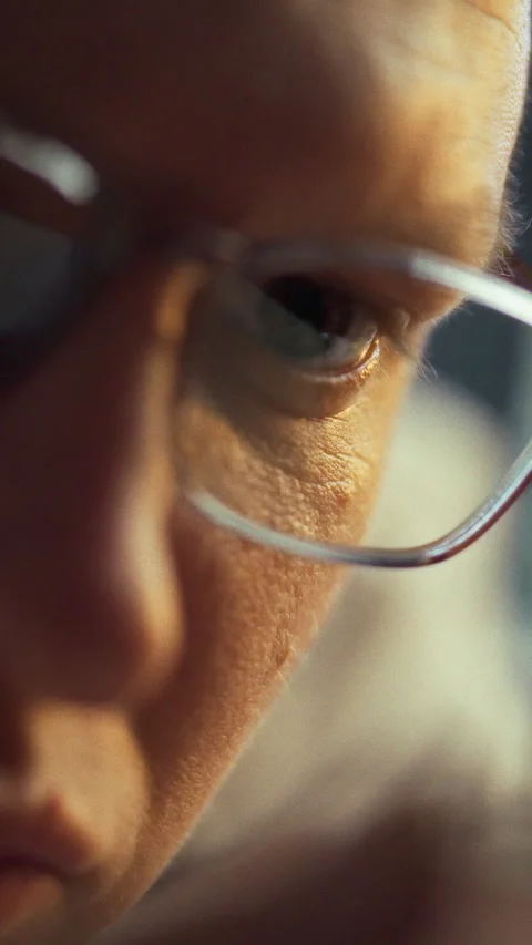 A person closely examines a small object eyes fixed intently lost in scrutin Stock Footage 331530157