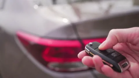 Person closes the car with a remote control key. Alarm system to protect the car Video stock 181924842