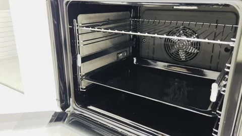 Person closing the door of a modern white oven Stock Footage 345145553