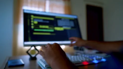 Person coding on a computer with a blurred screen Stock Footage 315982043