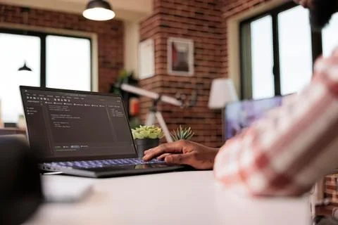 Person coding on laptop in cozy home office Stock Photos