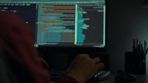 Person coding at night on a computer screen filled with colorful programming Stock Footage 288620760