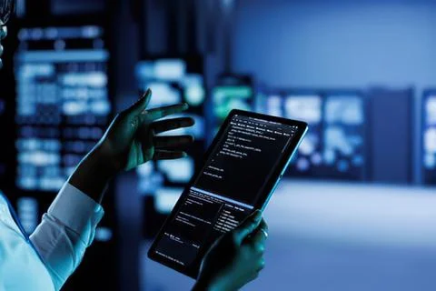 Person coding on tablet in server room Stock Photos