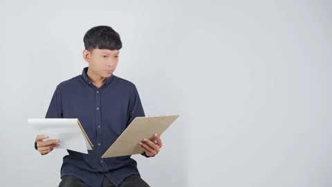 Person Comparing Documents While Considering Options Vídeo Stock 344830810