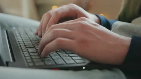 Person composing article on laptop in dim light. Person diligently typing on Stock Footage 338436241