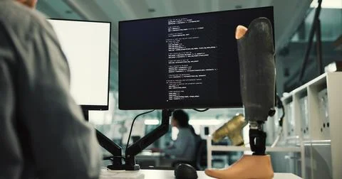 Person, computer screen and programming with prosthetic leg for robotic dev.. Stockfoto's