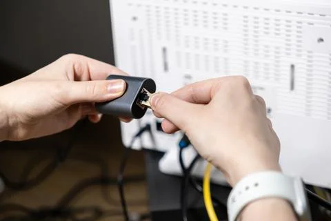 Person connecting an Ethernet cable into a network adapter, symbolizing cru.. Stock Photos