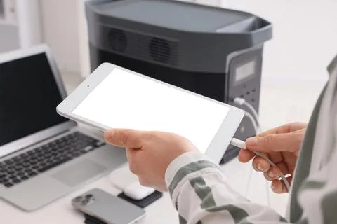Person connecting tablet to desktop computer with USB cable in modern workspa Stock Photos