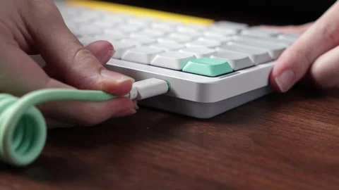 Person connects a white USB-C cable into a modern mechanical keyboard, show.. Stock Footage 320463882